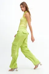 Pantalón cargo verde lima de satén, tiro medio y corte holgado con múltiples bolsillos.