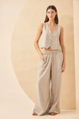 Pantalón palazzo color beige de lino, con cintura elástica y cordón ajustable.