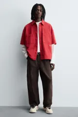 Zapatillas deportivas color crema con cordones, suela gruesa con diseño irregular y detalles en gris.