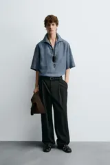 Camisa azul de lino con cuello polo, corte holgado y mangas cortas.