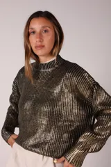 Buzo negro con lentejuelas doradas, cuello alto y mangas largas.