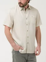Camisa de manga corta color beige, marca RKF, confeccionada en tencel. Tiene botones claros, bordado de pato al tono y pinza en la espalda.