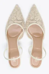 Zapato destalonado color blanco hueso, con tacón fino y punta fina. Capellada de mesh con bordados florales.