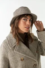 Sombrero tipo bucket de lana color beige con textura tweed.