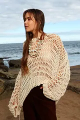 Sweater tejido a mano de algodón color crudo, de calce holgado, con cuello a la base y puños ajustados.