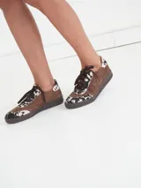 Zapatillas bajas marrones de gamuza con detalles de estampado animal print.