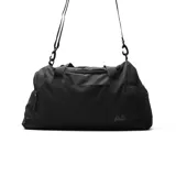 Bolso deportivo tipo duffel bag color negro, con asas de mano y correa ajustable para llevar al hombro. Presenta un pequeño logo con las letras "AS" en la parte frontal.