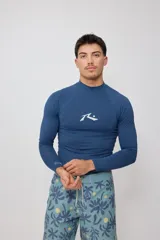 Rashguard azul con cuello alto y mangas largas, con logo de la marca estampado en blanco en el pecho.