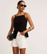 Short de cintura alta en sarga color blanco, con trabillas en la cintura, cierre tradicional, bolsillos, lunares de metal y strass aplicados.