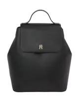 Mochila negra de poliuretano con forro de poliéster. Presenta un diseño estructurado con solapa superior que cierra con broche magnético y un asa de mano superior. En el centro de la solapa lleva un monograma metálico TH.