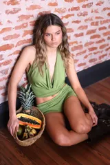 Blusa corta color verde oliva con cuello halter y escote drapeado/abullonado. La espalda está descubierta.