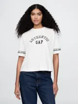 Remera corta color blanco con logo de Gap estampado en el frente y mangas cortas con detalle de rayas horizontales.