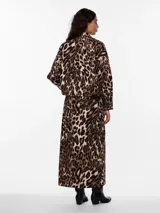 Camisa animal print con estampado de leopardo en tonos marrones y beige. Tiene cuello camisero, mangas largas con puños abotonados, cierre frontal con botones y dos bolsillos de parche en el pecho.