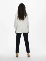 Sweater de tejido de punto color blanco roto, con escote en V y mangas largas. Presenta un calce ajustado y suave.