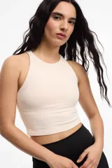 Top deportivo color crema, con espalda baja y copas removibles.