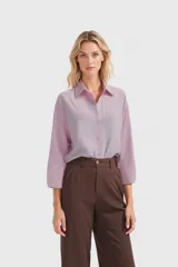 Camisa color lila con cuello clásico, cierre frontal con botones y mangas 3/4.