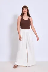 Pantalón palazzo de lino color crudo, con cintura alta y pinzas delanteras.