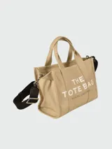 Bolso tote pequeño de lona color azul con estampado frontal de la marca en color blanco y correa de hombro negra.
