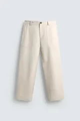 Pantalón color beige de corte recto, con bolsillos frontales tipo parche y bolsillos traseros ribeteados.