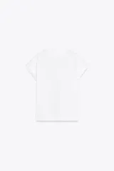 Camiseta blanca de algodón con cuello redondo, manga corta con dobladillo y dos bolsillos de parche en el frente con detalle de aplicación metálica.