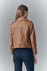 Campera negra de cuero ovino, estilo rocker, con cinturón, charreteras y solapas. Tiene cierres y detalles metálicos en frente y espalda.