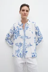Camisa de manga larga con estampa floral en tonos azules sobre fondo blanco.