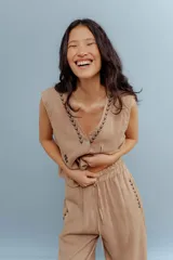 Chaleco color beige de lino con bordados en el cuello y en la parte inferior. Tiene cuello en V y cierre con botones.