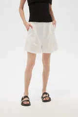 Bermuda blanca de viscosa con pinzas, corte holgado y tiro alto.