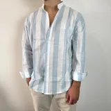 Camisa celeste y blanca a rayas verticales, de lino, con cuello mao y mangas largas con puños.