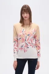 Sweater de tejido liso, manga larga y cuello redondo, con un estampado floral grande en tonos rosados, azules y amarillos sobre un fondo beige que se difumina a blanco en el ruedo.
