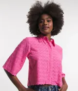 Camisa corta color rosa con textura de flores, escote camisero, manga corta, abotonado frontal y bajo con recorte ondulado.