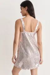 Vestido corto de fiesta, cubierto de lentejuelas plateadas, con escote en V y flecos de tul color crema.