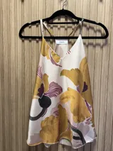 Top con breteles finos, escote en V y estampado de flores grandes en tonos dorados y borgoña sobre fondo beige.