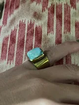 Anillo plateado con piedra blanca irregular.