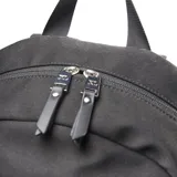 Mochila negra de tela con cierre doble, asa fija, forro interior textil, porta notebook y múltiples bolsillos externos.