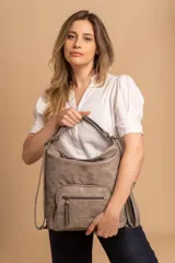 Cartera mochila color tostado, símil cuero, con compartimiento principal amplio y bolsillos frontales con cierre. Tiene correas ajustables para usar como mochila y asa superior para llevar al hombro.