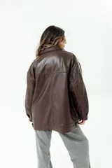 Chaqueta bomber marrón de cuero ovino con fit oversize, forrada en acetato con guata y raya blanca en la manga.