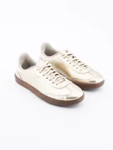 Zapatillas urbanas plateadas con suela marrón.
