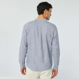 Camisa celeste de lino con cuello mao, manga larga con puños abotonados, cierre frontal con botones y bolsillo de parche en el pecho.