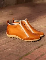 Zapatito marrón de cuero con puntera de gamuza, cierre frontal con cremallera y tirador trasero.