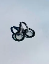 Par de aros colgantes con argollas doradas y dijes circulares de resina transparente con incrustaciones de strass de colores. El dije mide aproximadamente 1.5cm de diámetro.