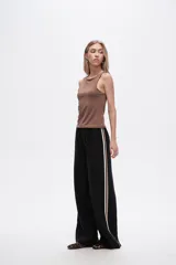 Pantalón negro ancho de viscosa con vivos laterales en blanco, dorado y marrón.