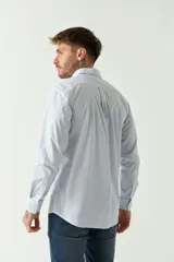 Camisa celeste a rayas rojas de hombre, manga larga, con bolsillo y logo bordado.