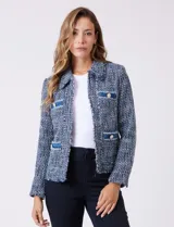 Chaqueta de tweed azul con cuello a la base, abertura central y bolsillos delanteros. Presenta puños con aplique de botones perlados y terminación desflecada. Incluye forro interno.