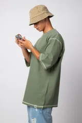 Remera negra oversize con mangas cortas y costuras a la vista en color blanco.