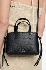 Bolso de mano Bimba y Lola modelo Chihuahua, tamaño mini, color marrón topo, fabricado en piel con piezas de metal plateado. Presenta estructura blanda, cierre con cinta de piel, logo metálico, bolsillo interior con cremallera e interior con logo grabado.