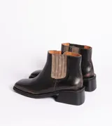 Bota corta negra de cuero con elástico lateral, caña de 12 cm y taco de madera de 4 cm.