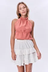 Top color salmón con cuello halter con volados y corte crop.