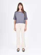 Pantalón de jean blanco, de corte recto y tiro alto, con terminación desflecada en el ruedo.