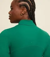 Campera deportiva color verde agua, confeccionada en microfibra, con cierre frontal, cuello alto, recortes en el frente y bolsillos laterales.
